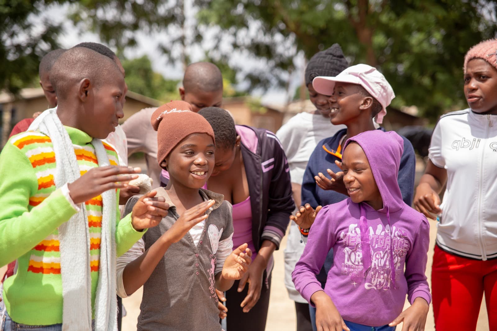 A group of adolescent girls and young women in animated conversation during a Trinity Project peer-education session.